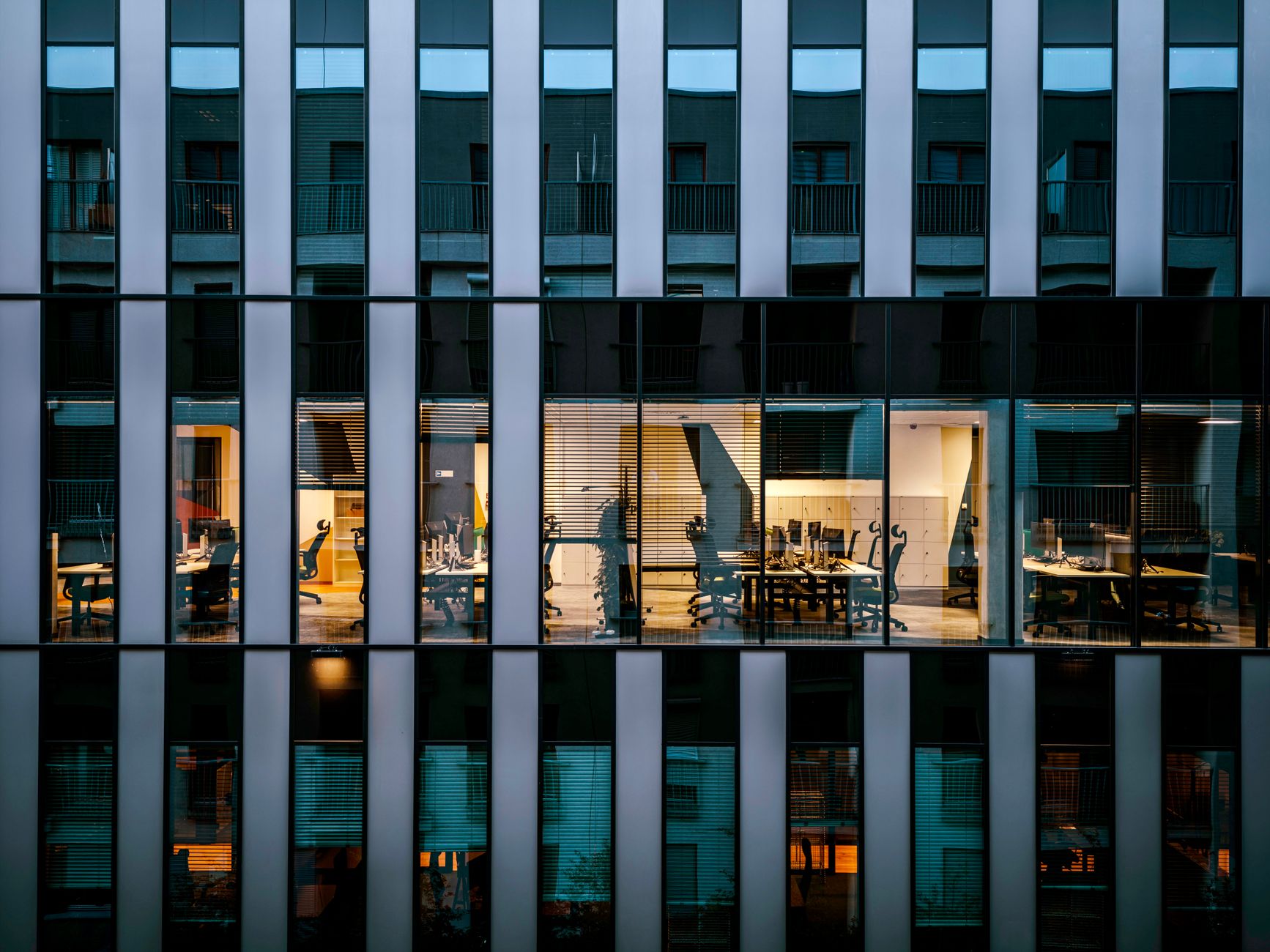 Façade vitrée d’un immeuble de bureaux, la nuit